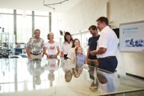Einführung am Kraftwerksmodell Tourguide Johann Schweighofer begrüßt eine Besuchergruppe am Kraftwerksmodell und erklärt den Aufbau des Donaukraftwerks Ybbs-Persenbeug.