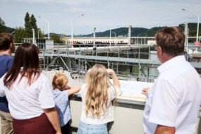 Schleusenvorgang in Persenbeug Tourguide Johann Schweighofer beobachtet mit einer Besuchergruppe die Schleusung eines Transportschiffes in der Schleuse Persenbeug.