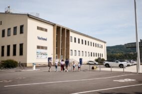 Start der Kraftwerksführung Besucherinnen und Besucher gehen über den Parkplatz zum Betriebsgebäude des Donaukraftwerks Ybbs-Persenbeug, wo die Kraftwerksführung beginnt.