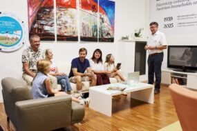 Stromverbrauch heute und früher Besucherinnen und Besucher im modernen Wohnzimmer, während Tourguide Johann Schweighofer den Stromverbrauch heute und früher erklärt.